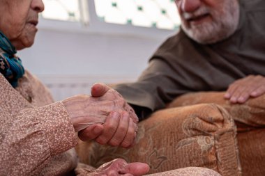 Arap yaşlı çiftler el ele tutuşurken birbirlerini severler.