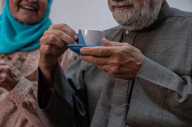 Arap yaşlı çiftler birlikte kahve içiyor.
