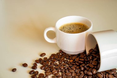 Kahve fincanları beyaz arka planda kahve çekirdekleri ve kahve içecekleriyle dolu.