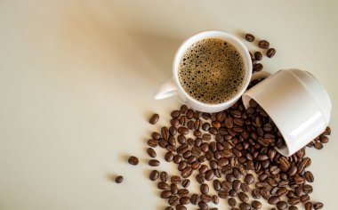 Kahve fincanları beyaz arka planda kahve çekirdekleri ve kahve içecekleriyle dolu.