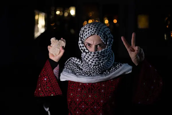 Stock image portrait for old woman holding stone which represents the only weapon against the occupation and will be the road to freedom