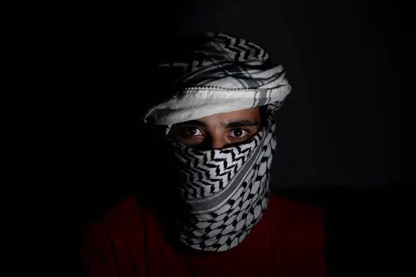 stock image portrait of pearson wearing white keffiyeh on dark background with anger expression on his eyes due to violence and against occupation