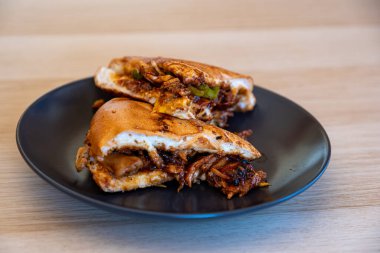 İtalyan biber ve mangal sosu dolu siyah tabakta tavukla ahşap masa üzerinde soslu soslar.