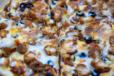 Ev yapımı pizza ahşap kesim tahtasından ve zeytin soslu.