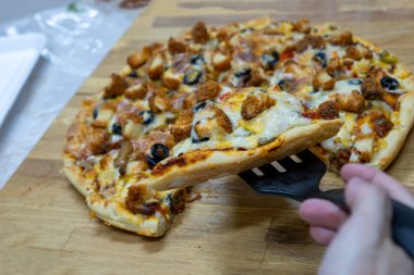 Ev yapımı pizza ahşap kesim tahtasından ve zeytin soslu.