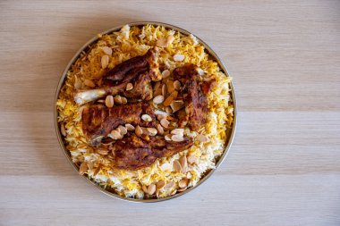 Tahta masadaki üst manzaralı bademlerle kaplı et ve pirinç tabağı.