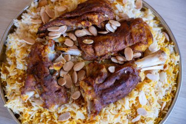 Tahta masadaki üst manzaralı bademlerle kaplı et ve pirinç tabağı.