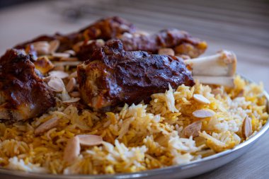 Tahta masadaki üst manzaralı bademlerle kaplı et ve pirinç tabağı.