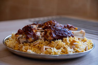 Tahta masadaki üst manzaralı bademlerle kaplı et ve pirinç tabağı.