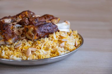 Tahta masadaki üst manzaralı bademlerle kaplı et ve pirinç tabağı.