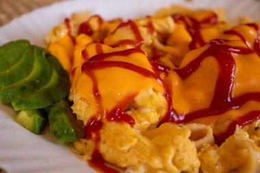 Yanında ketçap soslu yumurta ve peynir. Biraz da avokado.