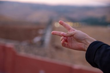 Kadın eli ya 2 yapıyor ya da zafer işareti yapıyor.