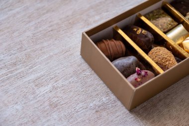 Top-View of Luxury Chocolate Box with Multiple Varieties in Stunning Golden Hues. Elegant Packaging with Copy Space. Perfect for Celebrations, Gifts, and Indulgent Occasions clipart
