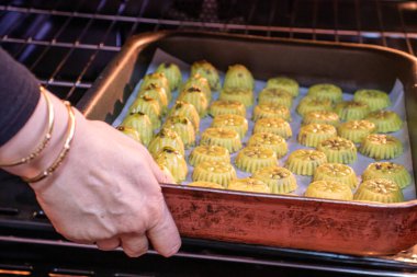 Keto bayram yemeğini fırına koyarken Arap kadın eli.