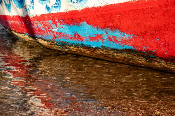 stock image old rustic ship paint on seaside with water reflection