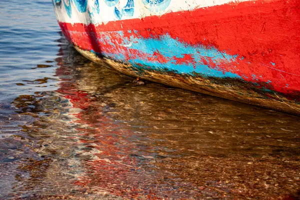 stock image old rustic ship paint on seaside with water reflection