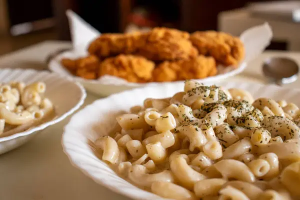 stock image macaroni served with chicken nugget on table topped with spices and herbs with cream sauces and called bechamel