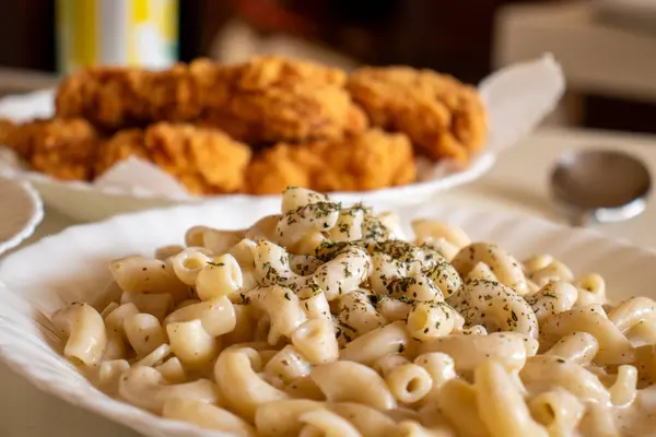 stock image macaroni served with chicken nugget on table topped with spices and herbs with cream sauces and called bechamel