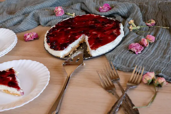 stock image Cold cheesecake with cherry jelly served on wooden table with forks flowers roses and green veil