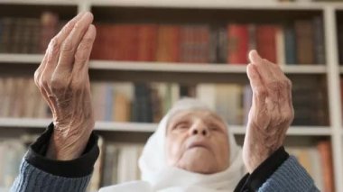 Arap yaşlı kadın merhametli Allah 'tan yardım ve destek diliyor. 