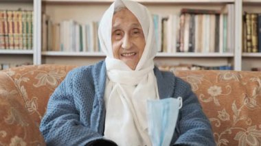 Tıbbi maske takan Arap bir kadın enfeksiyon kapıp kendimizi korumamız gerektiğini söylüyor.
