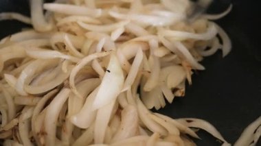 Soğanlar hala beyaz ve yarı tazeyken, soğanın tavada kızarması için yakından bakın.