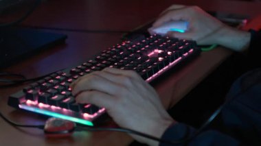 Orta yaşlı erkek elleri klavyede Klavye ve fareden yayılan RGB ışıklarıyla yazma ya da çalışma