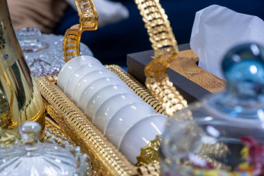 Beyaz parlak Arap kahve fincanları altın renkli tutacakta.