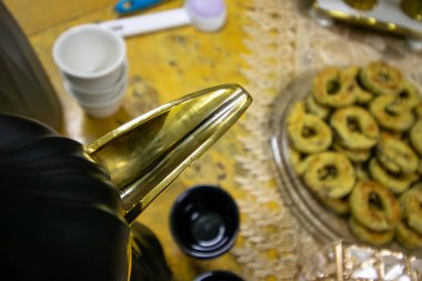 Arap kahve demliği ucu için en iyi manzara ve ahşap masa üzerinde arka planda fincanları olan bayram tatlısı