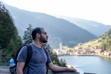 Tatillerinde arka planda göl olan Arap erkek portresi