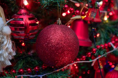 Noel ağacında Noel oyuncağı topu. Etrafı şenlikli ışıklarla çevrili. Tatil günü. Yeni yıl. Noel zamanı. seçici odak
