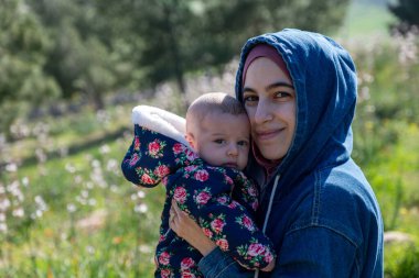 Anne ve bebek yeşil tarlalarda piknikte birlikte vakit geçirip güzel anılar yaratıyorlar.