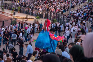 Stadyum sandalyelerinde izleyiciler mezuniyet kutlamalarını izliyorlar. Aileleri ve akrabaları için el sallıyorlar, onlar için seviniyorlar. (Jordan, 24 Temmuz 'da Ürdün Bilim ve Teknoloji Üniversitesi)