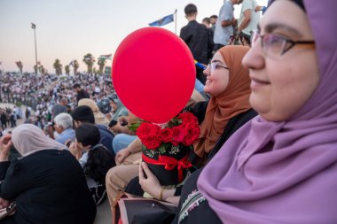 Oğlu mezuniyeti için hediyeler taşıyan Arap bir aile onun başarılarına bakıyor ve lisans diplomasını alıyor.