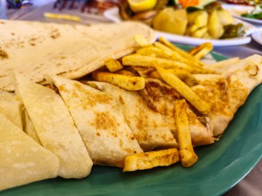 Geleneksel Orta Doğu Shawarma soslu, yanında da kızarmış patates. Lezzetli sokak yemekleri ve kültürel mutfağın mükemmel bir temsilcisi.