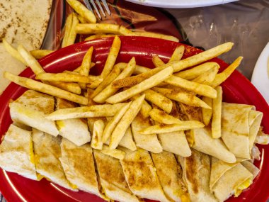 Geleneksel Orta Doğu Shawarma soslu, yanında da kızarmış patates. Lezzetli sokak yemekleri ve kültürel mutfağın mükemmel bir temsilcisi.