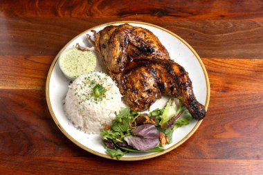 Yarım kızarmış tavuk, beyaz pirinç ve yeşil sos.