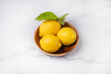 Tahta bir kasede üç limon.