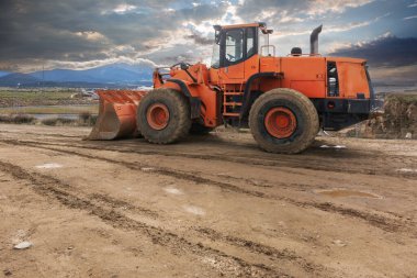 Kazıcı inşaat alanında bir yol inşa ediyor.