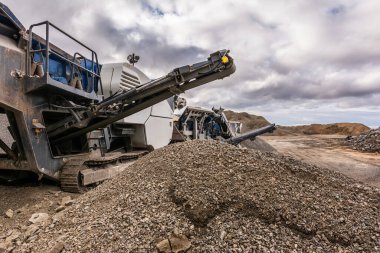 Taş ocağındaki ağır ve seyyar makineler taşları inşaat malzemesine dönüştürüyor.