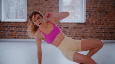Güzel bir vücudu olan, boş, aydınlık bir odada egzersiz yapan sportif bir kadın. Spor kıyafetleri giymiş spor salonunda esneme hareketleri yapan bir kız antrenör. Büyük, havadar bir uzay spor salonunda spor yapan bir sporcu..