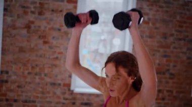 Güzel bir vücudu olan, boş, aydınlık bir odada egzersiz yapan sportif bir kadın. Spor kıyafetleri giymiş spor salonunda esneme hareketleri yapan bir kız antrenör. Büyük, havadar bir uzay spor salonunda spor yapan bir sporcu..