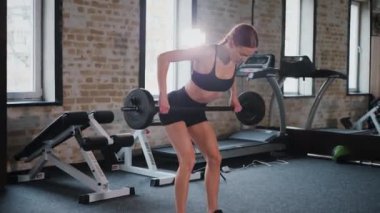 Spor salonunda halterle çömelmiş bir kadın. Spor meraklısı ağırlıklarla çömelme hareketi yapıyor. Güçlü kadın antrenmanda halter kaldırıyor. Spor salonunda halterle egzersiz yapan bir kadın. Kadın spor salonunda çekirdek egzersizi yapıyor. Spor salonundaki spor meraklısı.. 