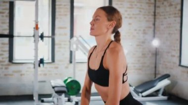 Kettlebell 'i kararlılıkla kaldıran kadın. Kettlebell 'le spor yapıyorum. Güç eğitimi iş başında. Kettlebell kaldırma ile fitness odağı. Kadın spor salonunda çekirdek egzersizi yapıyor. Spor salonundaki spor meraklısı.. 