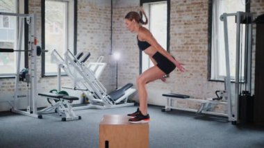 Fitness meraklısı engelin üzerinden atlıyor. Jimnastik: engelin üzerinden atlayan kadın. Fitness meraklısı spor salonunda vücut egzersizi yapıyor. mekik çekerken karın kaslarına odaklanan bir kadın. Kadın spor salonunda vücut egzersizi yapıyor.. 