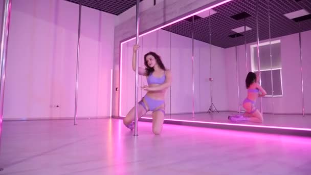 女性がポールダンスを踊る 鏡でいっぱいの部屋でキャプチャされた官能的なダンスの動き 優雅なダンサーは 反射的な表面を持つ部屋でポールを回転させます 動きのエレガンス 鏡に囲まれたポールダンスルーチンを演じる女性 — ストック動画