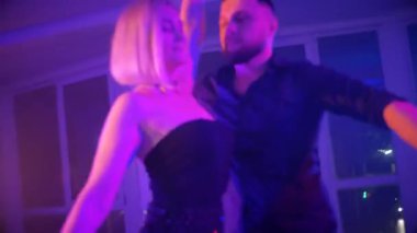 Canlı bir partide zarif bir şekilde tango yapan bir erkek ve kadın. Kizomba 'nın tutkusuna kapılmış iki dansçı. Tango kucaklaşmasında zarif hareket eden bir çift. Bir erkek ve kadın arasında büyüleyici bir dans anı. Gece diskosu partisinde. Aşık dansçılar