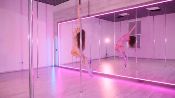女性がポールダンスを踊る 鏡でいっぱいの部屋でキャプチャされた官能的なダンスの動き 優雅なダンサーは 反射的な表面を持つ部屋でポールを回転させます 動きのエレガンス 鏡に囲まれたポールダンスルーチンを演じる女性 — ストック動画