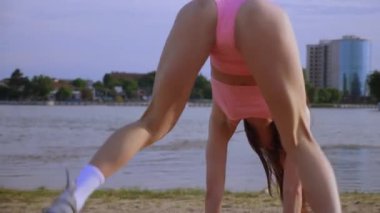 Sahilde dans eden seksi kız. Güzel bir kadın kalçasıyla kumda dans eder. Bikinili seksi kadın. Bikinili genç bir kadın kumların üzerinde enerjik bir dans ediyor..