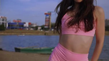 Sahilde dans eden seksi kız. Güzel bir kadın kalçasıyla kumda dans eder. Bikinili seksi kadın. Bikinili genç bir kadın kumların üzerinde enerjik bir dans ediyor..